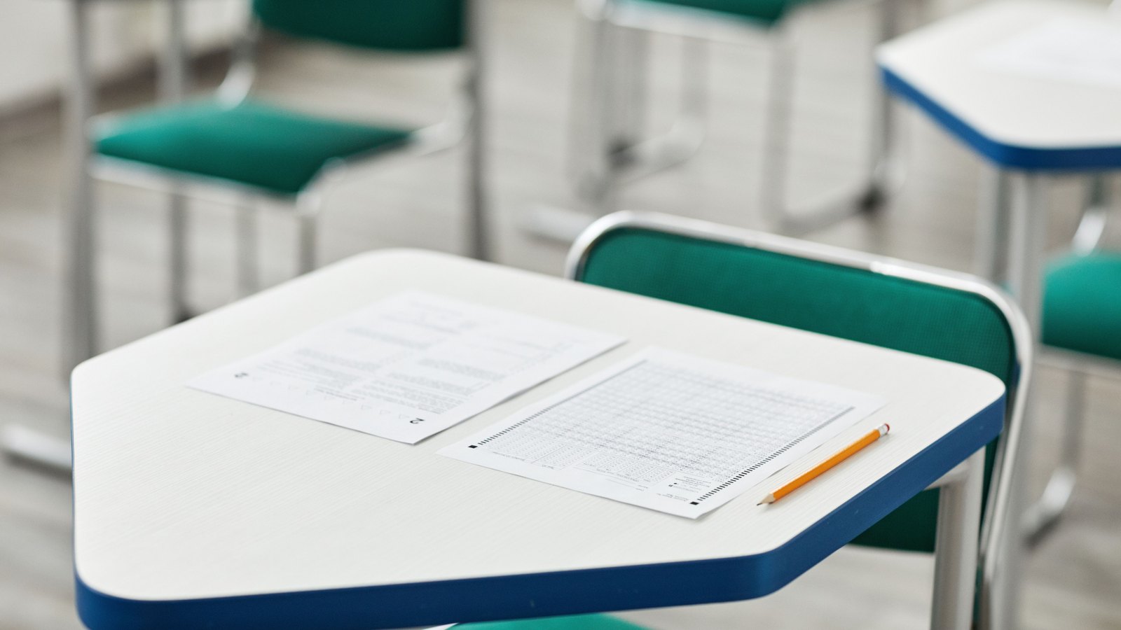 Multiple choice exam paper and pencil on a classroom desk